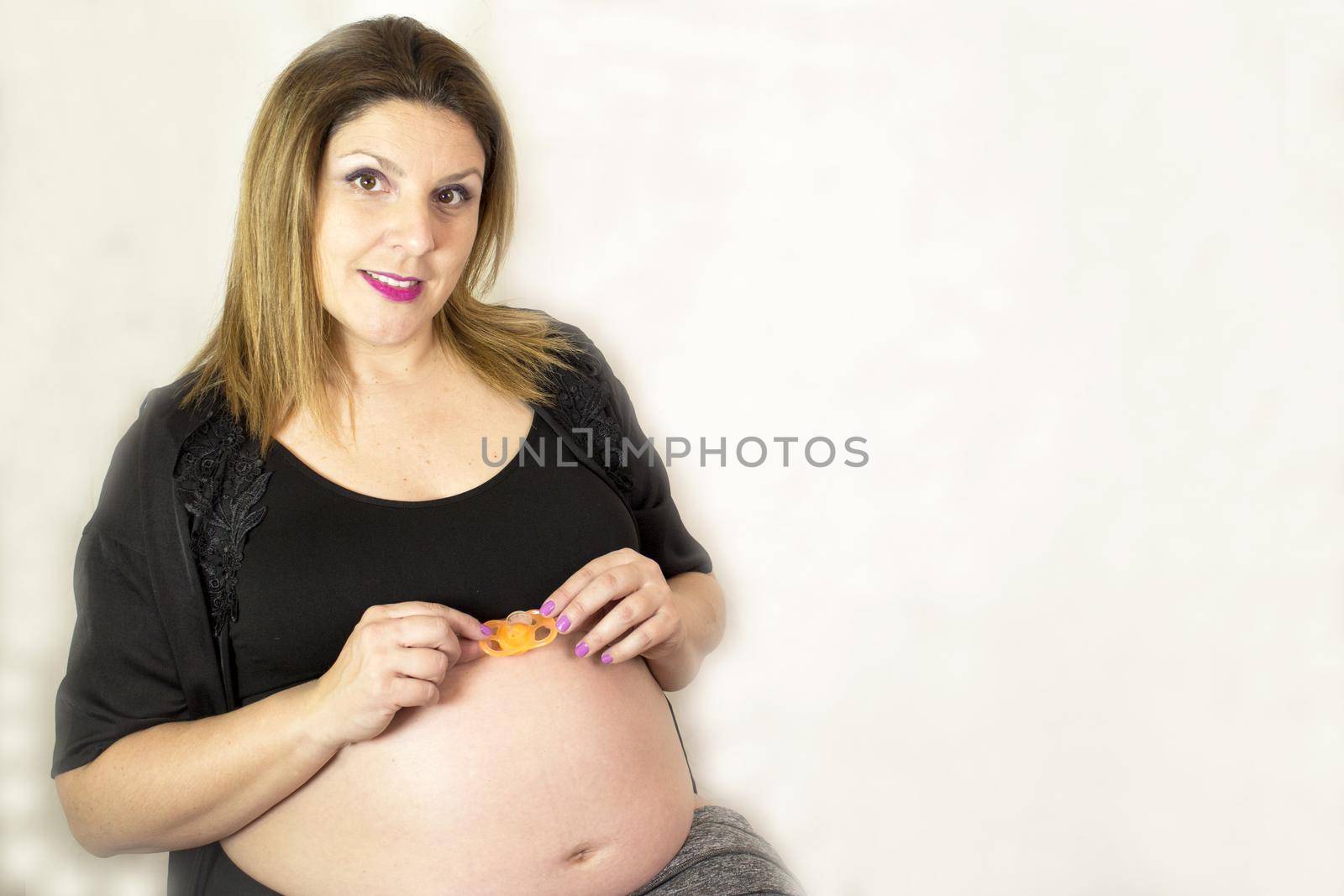 Eight month pregnant woman with pacifier in her belly by GemaIbarra