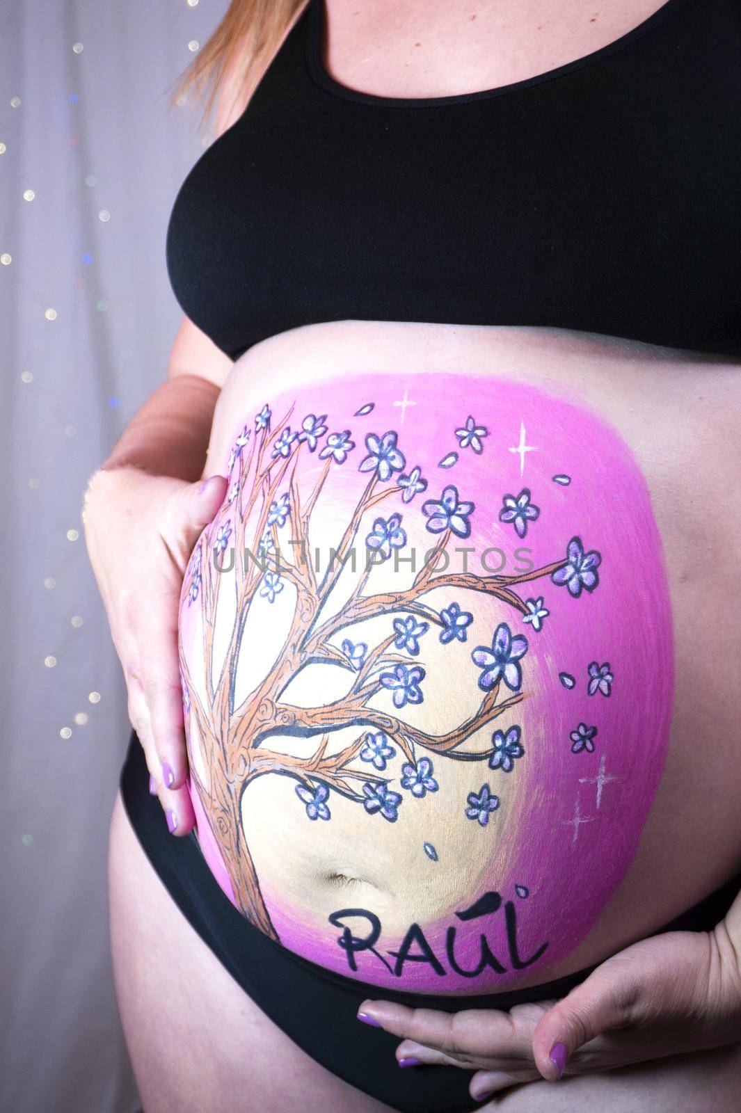 Pregnant woman with tree drawn on her belly. Pink color