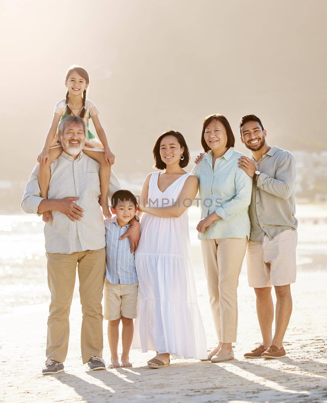 Always make time for your family. Full length shot of a happy diverse multi-generational family at the beach. by YuriArcurs