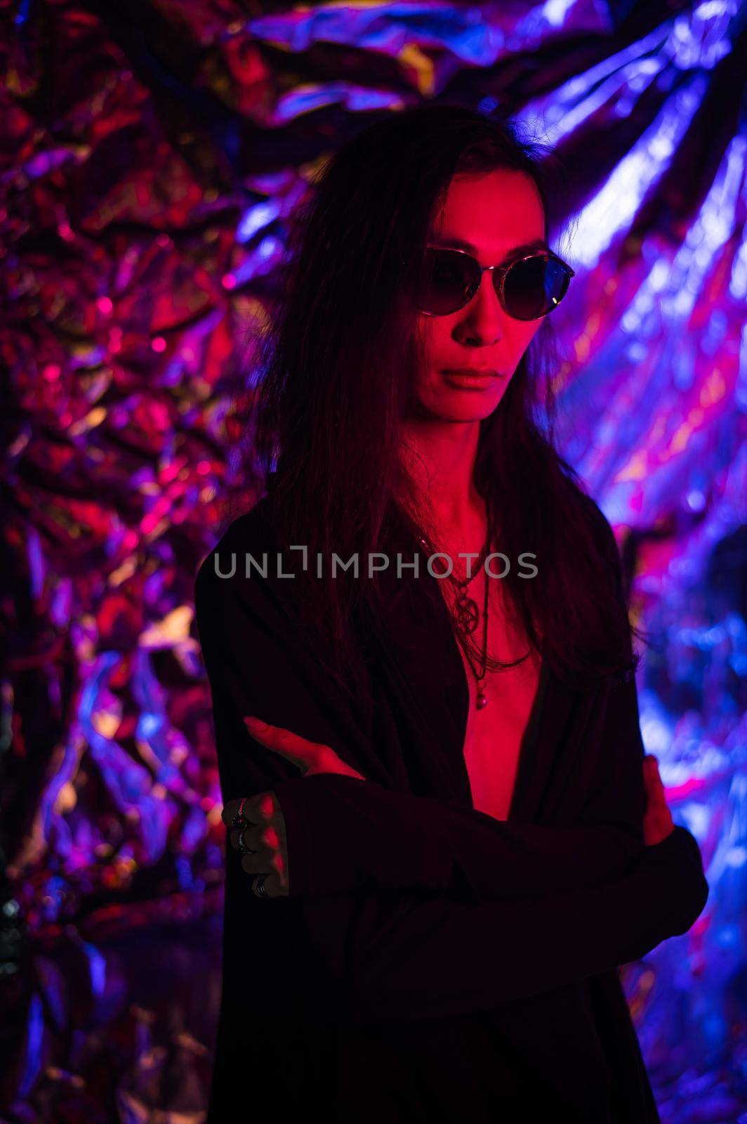 Portrait of a transgender model in sunglasses in a studio with neon lighting. by mrwed54
