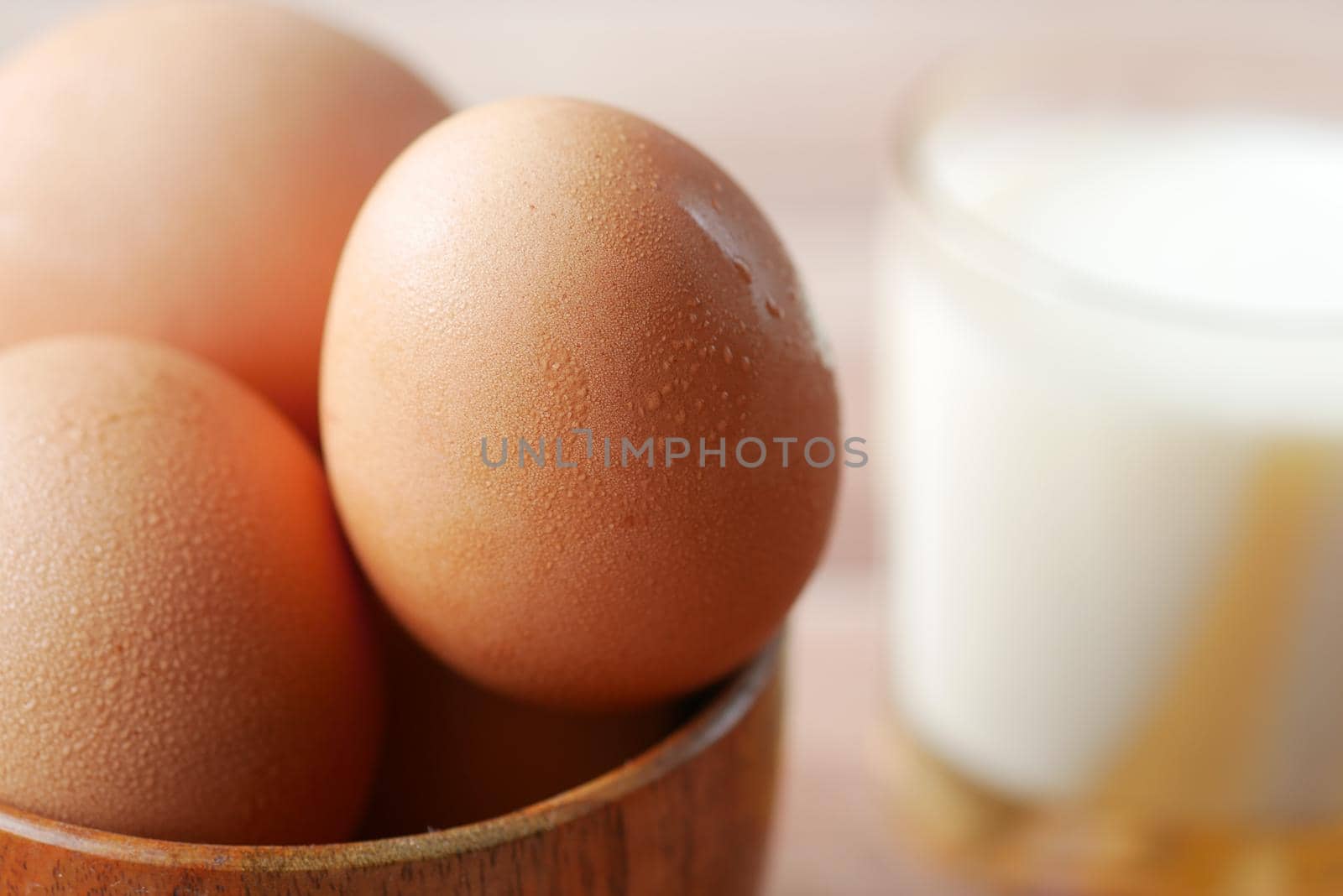 eggs in a bow and a glass of milk on table ,