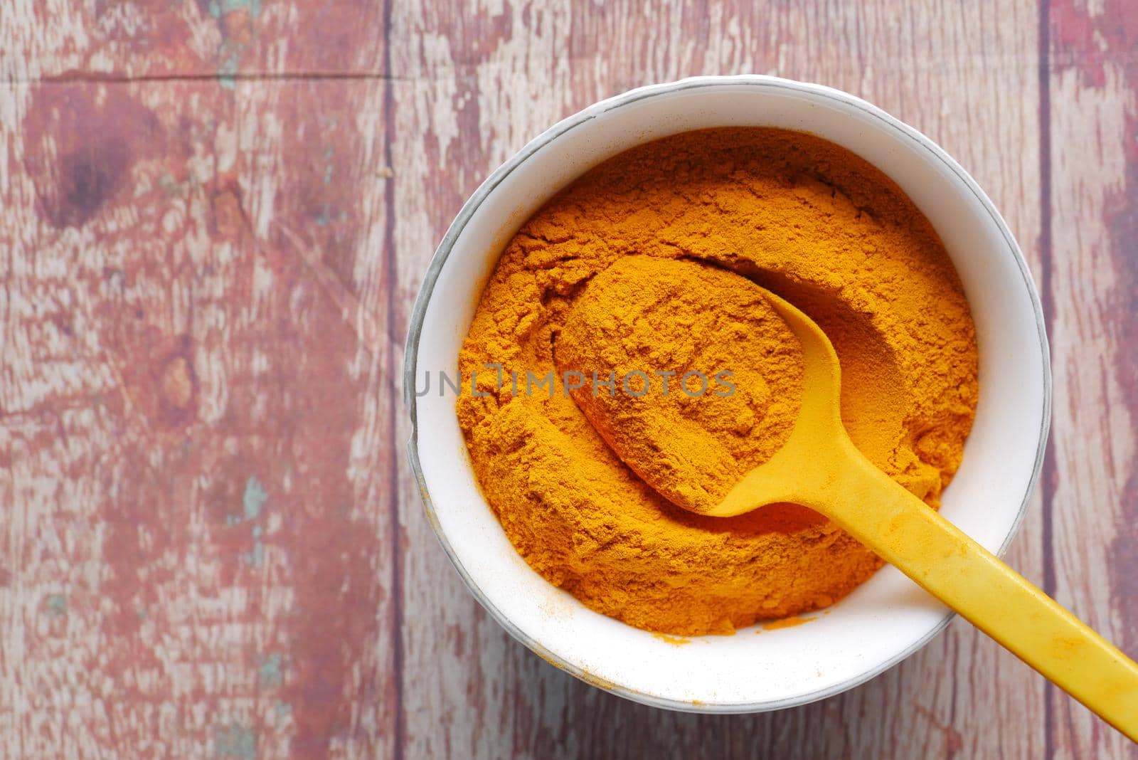 top view of turmeric root powder in bowl on table