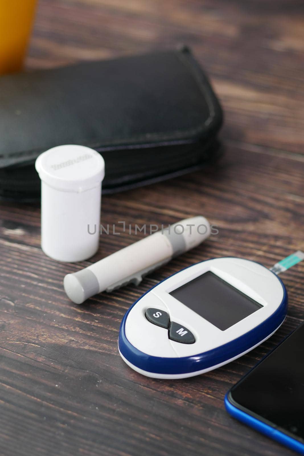 Close up of diabetic measurement tools and pills on pink background .