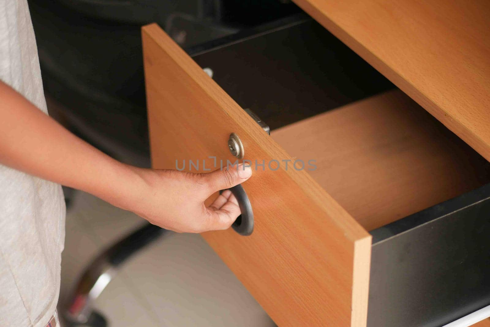 man's hand open drawer wooden in cabinet.