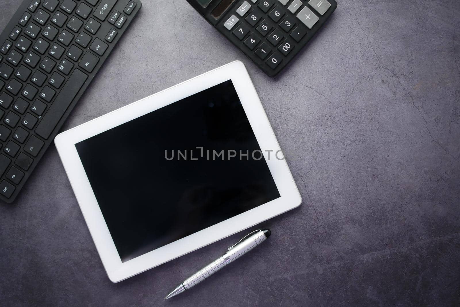 Flat composition of digital tablet and office stationary on black background .