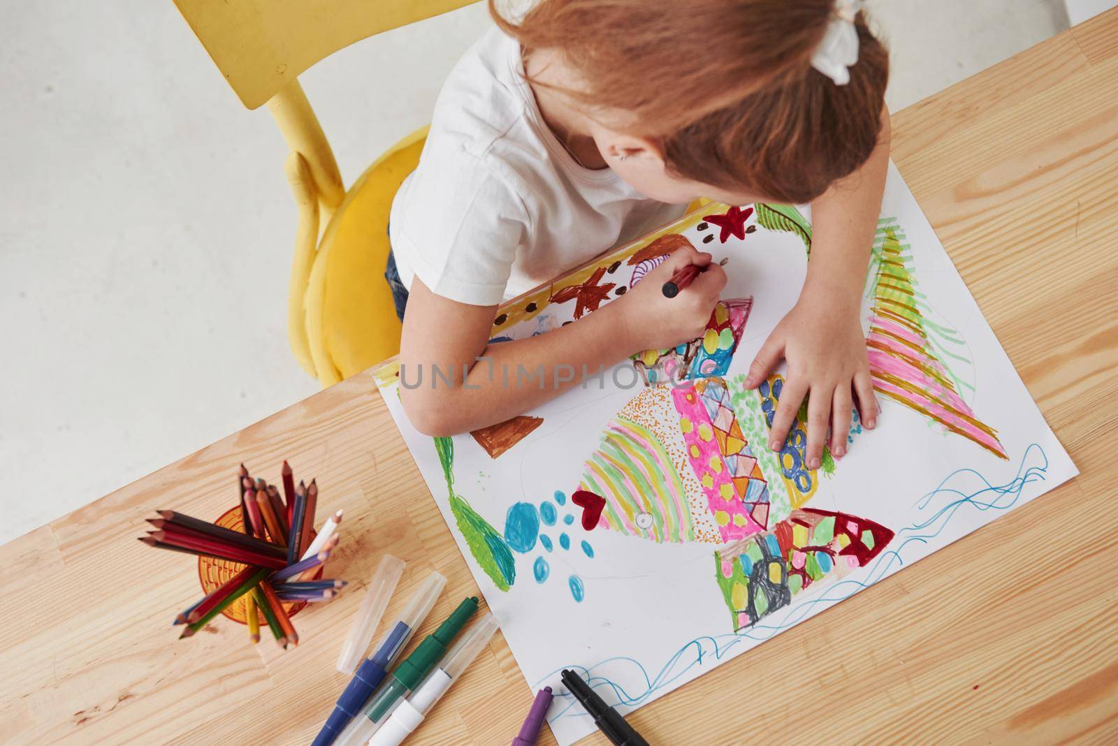 She loves that occupation. Cute little girl in art school draws her first paintings by pencils and markers.