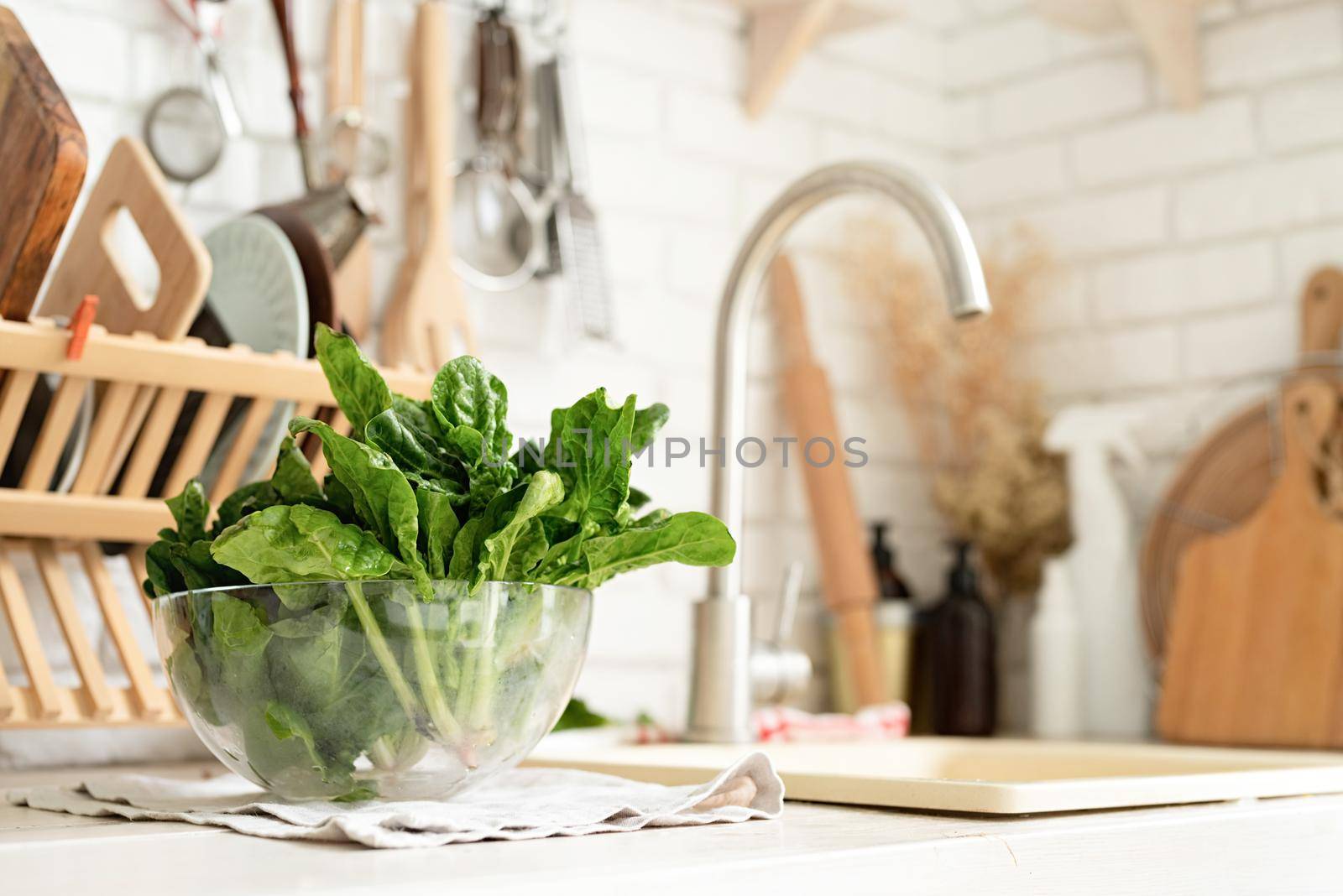 Preparing healthy foods. Healthy eating and dieting. fresh spinash in a bowl in the kitchen. Closeup of spinach