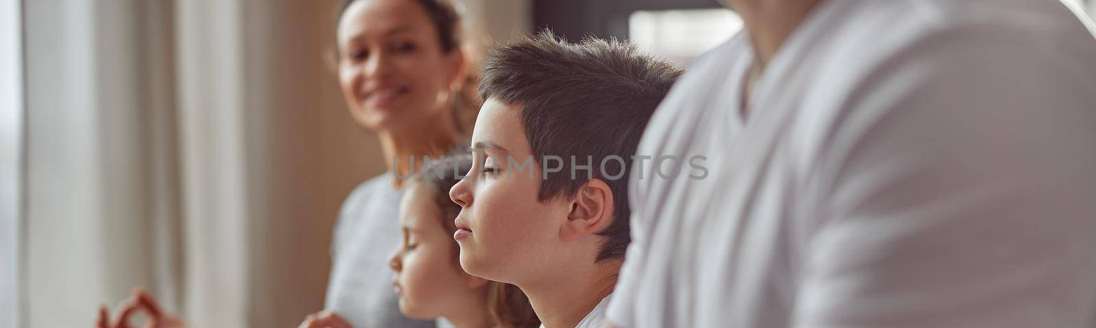 Cropped head of smiling woman watching her husband and kids doing mental practice at home together