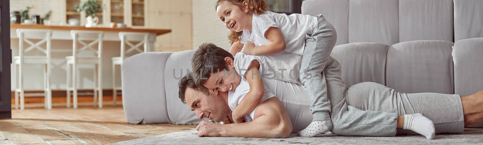 Happy family having fun together in living room by Yaroslav_astakhov