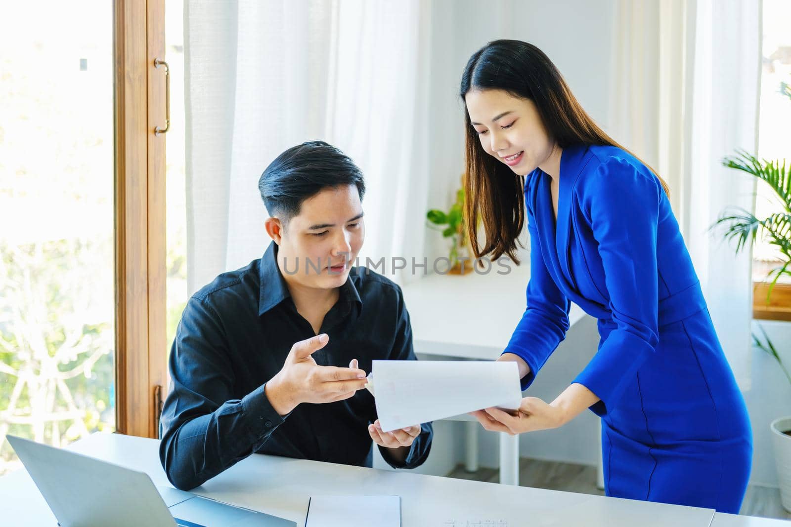 negotiation, analysis, discussion,asian female economist pointing out a document explaining the investment finance program to the company owner to plan marketing and hedging business risks