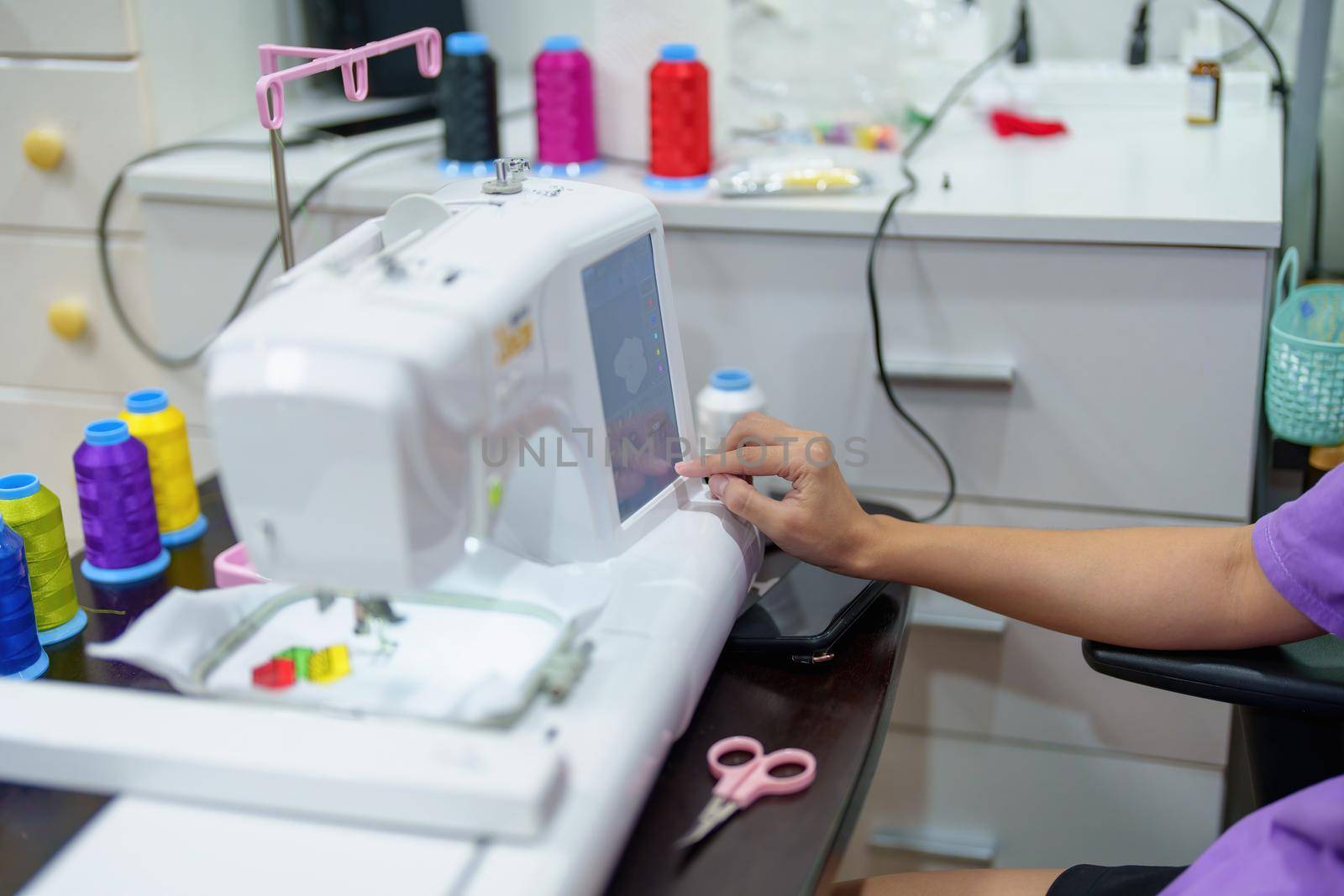 Embroidery, handicrafts, hobbies, SME business, family business, Portrait of Asian female designers are doing by designing patterns using automatic embroidery machines by customer order