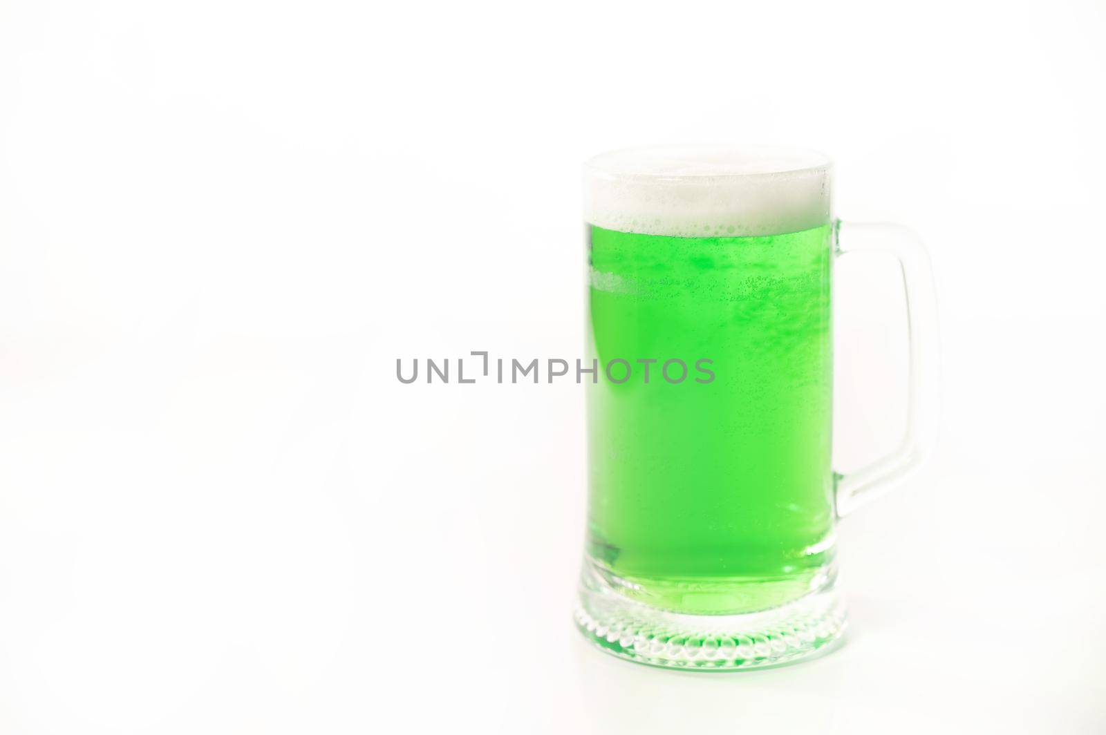 A pint of green beer for st patrick's day on a white background. Traditional Irish drink for a holiday. Copy space.
