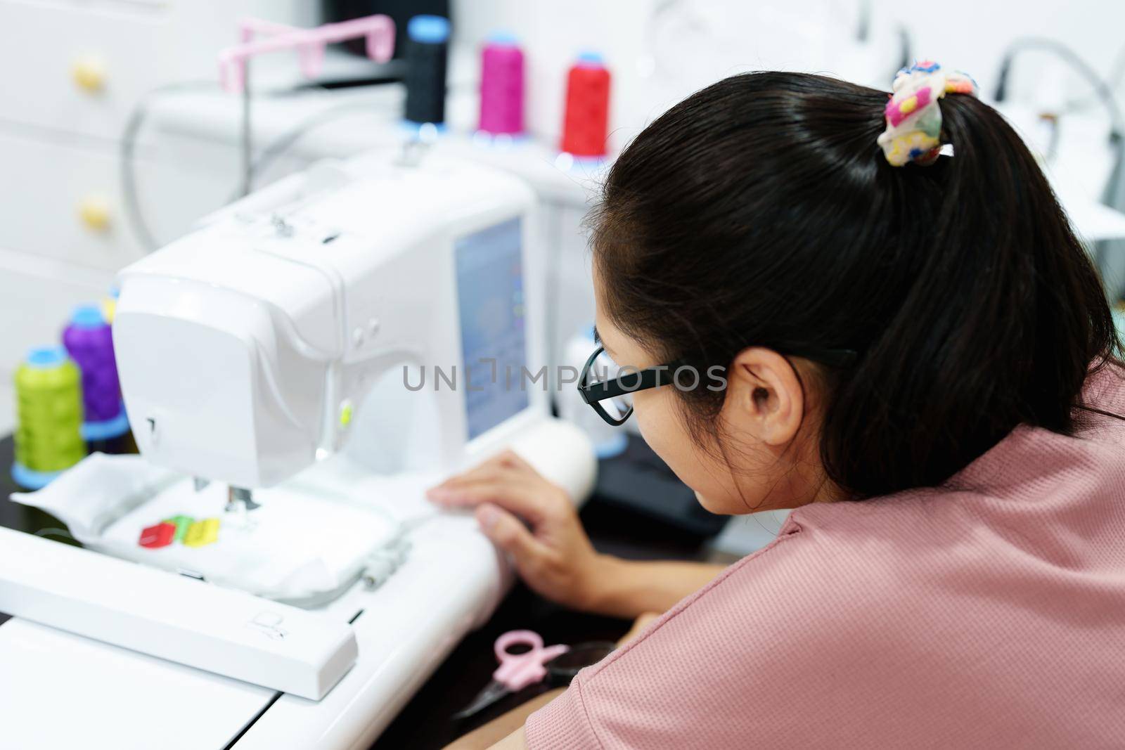 Embroidery, handicrafts, hobbies, SME business, family business, Portrait of Asian female designers are doing by designing patterns using automatic embroidery machines by customer order. by Manastrong