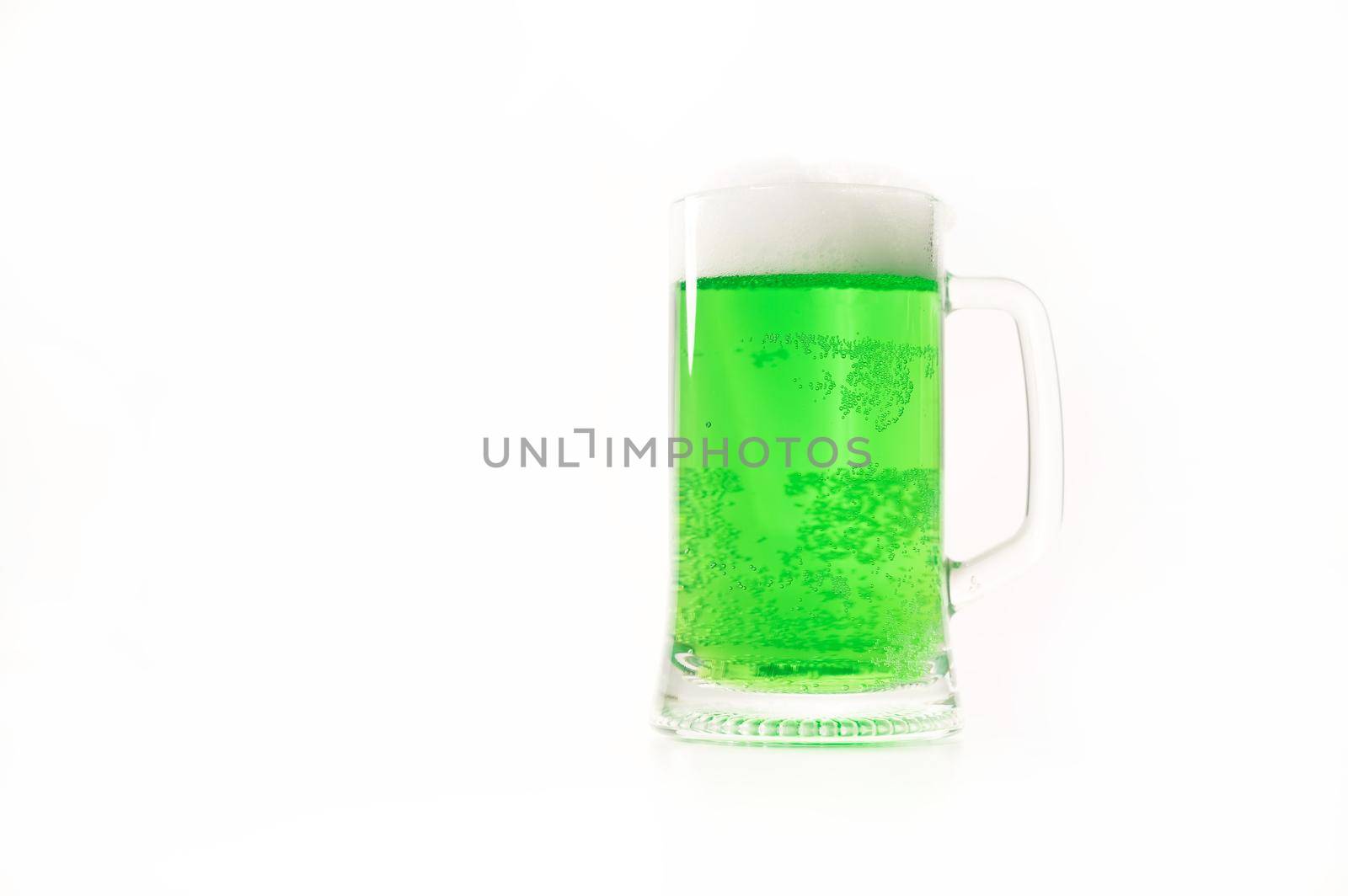 A pint of green beer for st patrick's day on a white background. Traditional Irish drink for a holiday. Copy space.