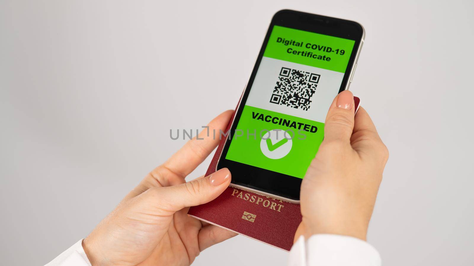 Woman holding passport and phone with qr code about vaccination