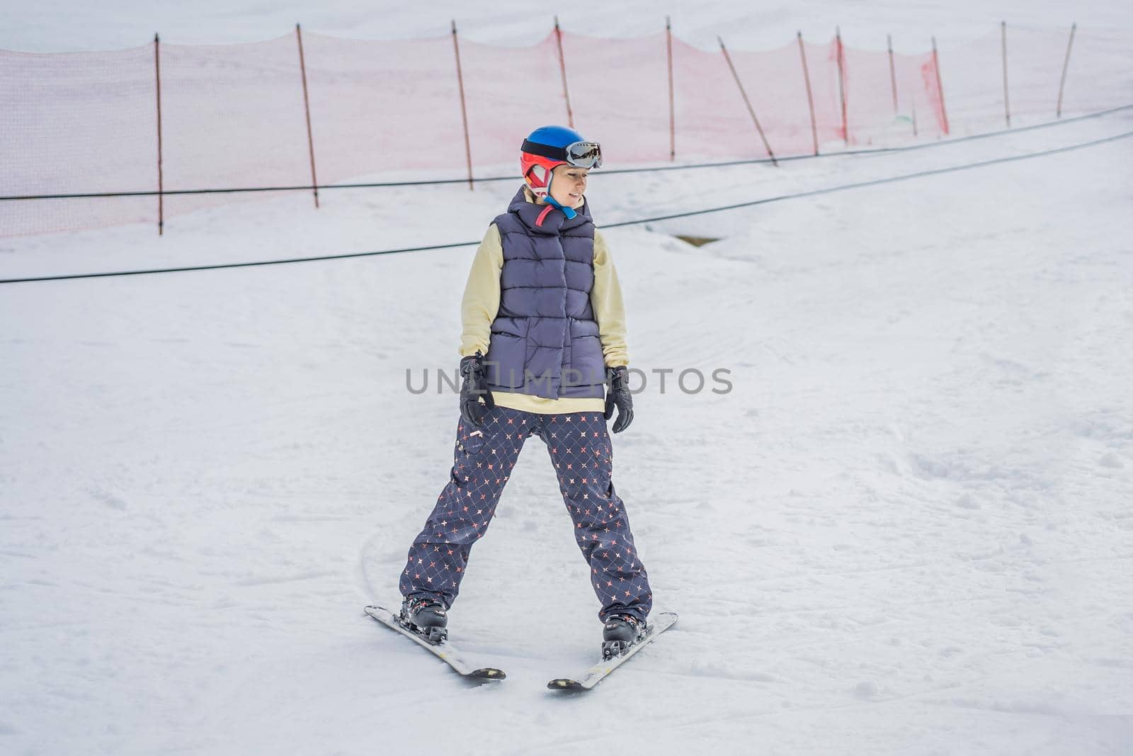 Woman learning to ski. Young woman skiing on a snowy road in the mountains.