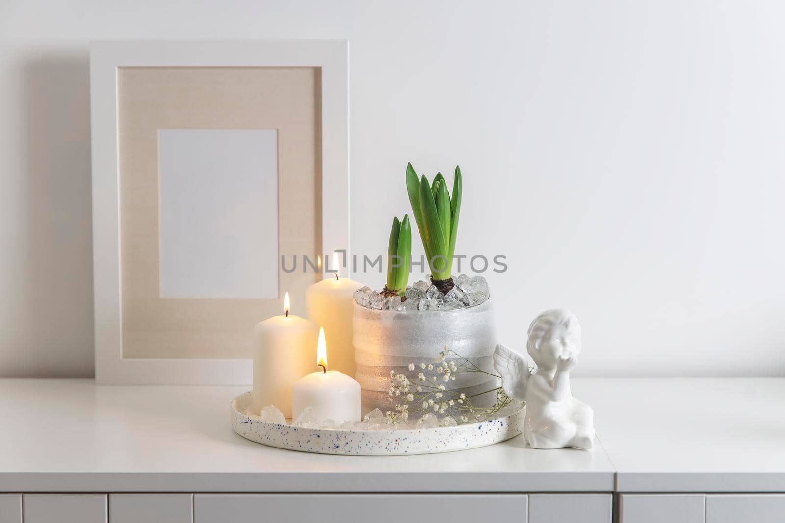 Unblown hyacinths with burning candles on a wooden vintage tray. Home decoration for spring