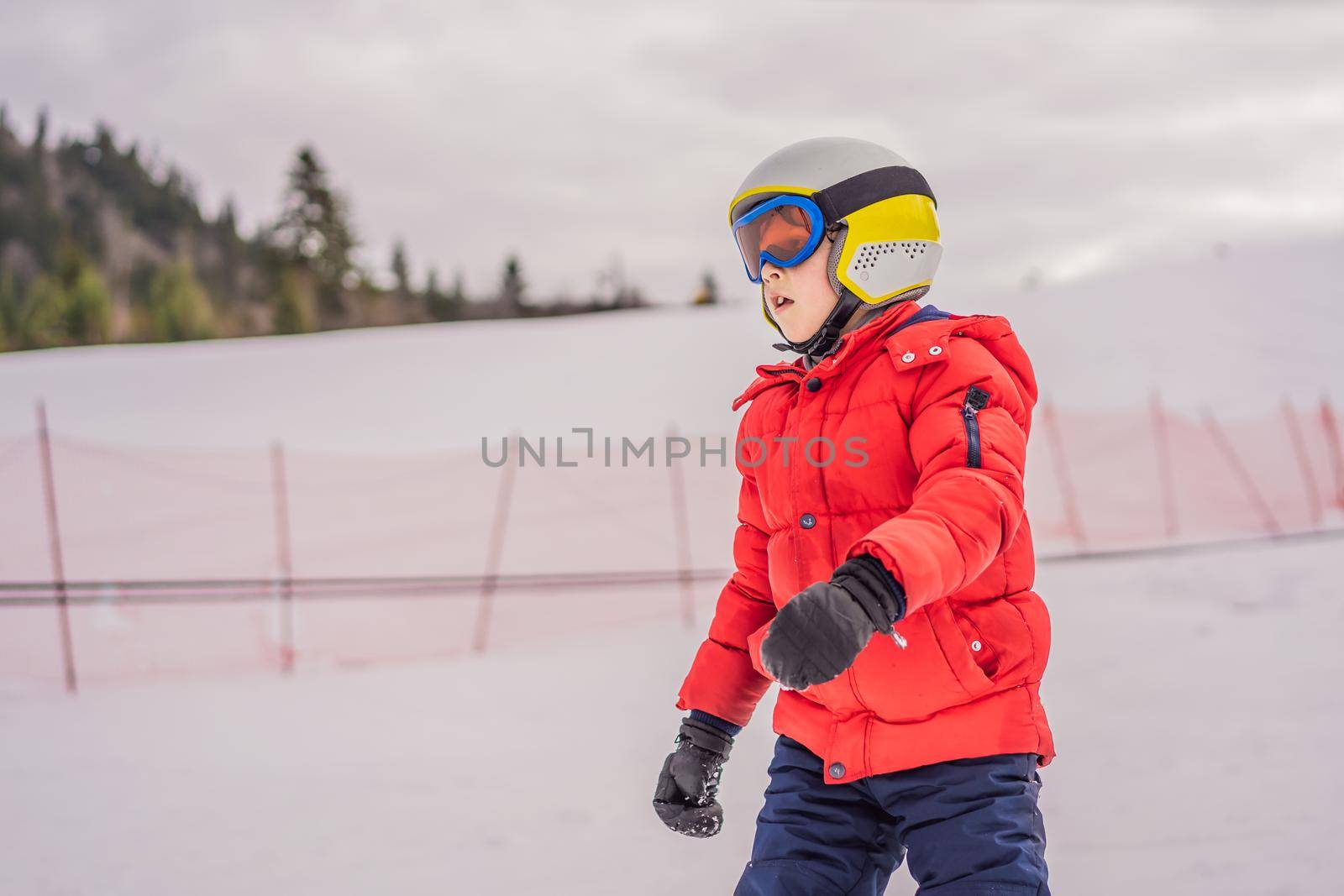 Child skiing in mountains. Active toddler kid with safety helmet, goggles and poles. Ski race for young children. Winter sport for family. Kids ski lesson in alpine school. Little skier racing in snow.