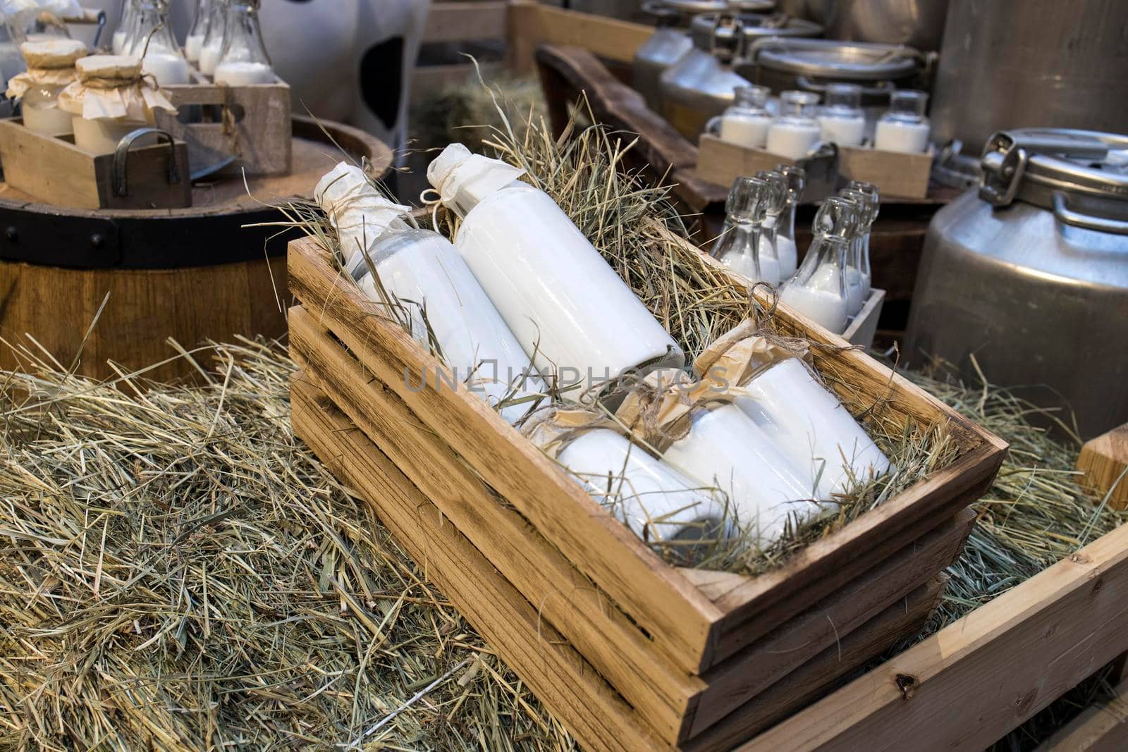 Milk - decoration on farm. Agriculture, farming. Farmer milk in bottles. Natural milk, organic milk. Vintage ornament with hay, straw and bottles with yogurt. Farmer product. Rustic decor. Products