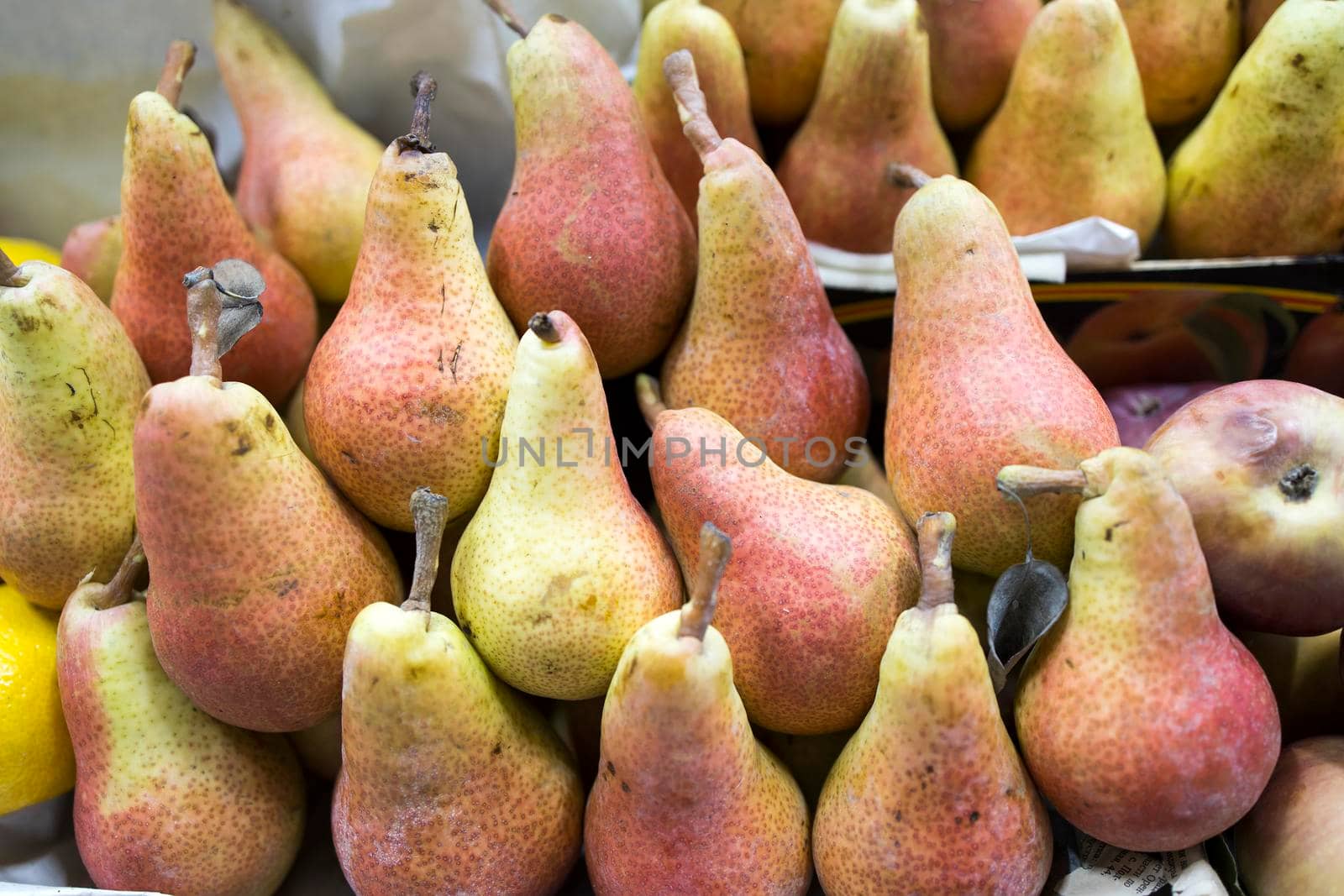 lots of yellow red pears for sale in the local market by elenarostunova