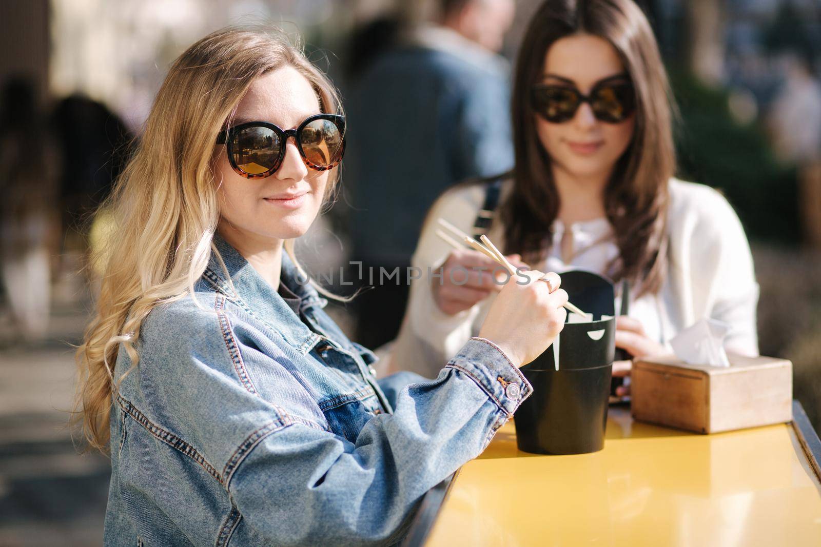 Delitious lunch of takeaway asian food outdoors. Best friends spend time together in pring sunny day.