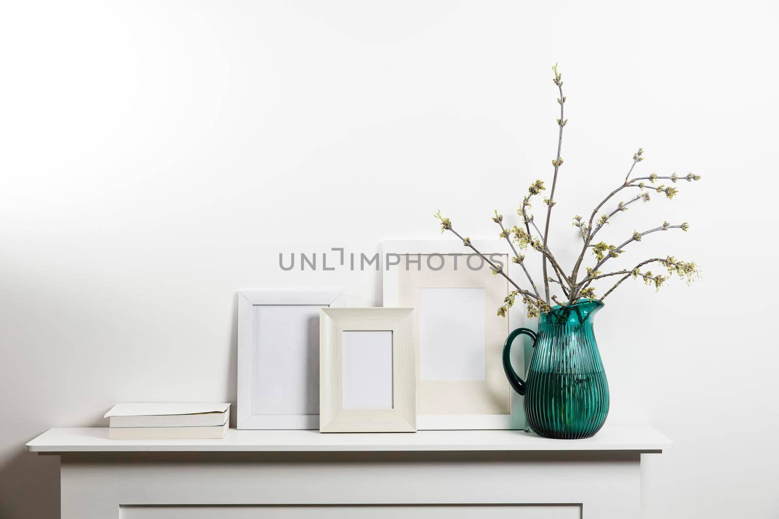 American maple branches in green glass jar and frame for photo by elenarostunova