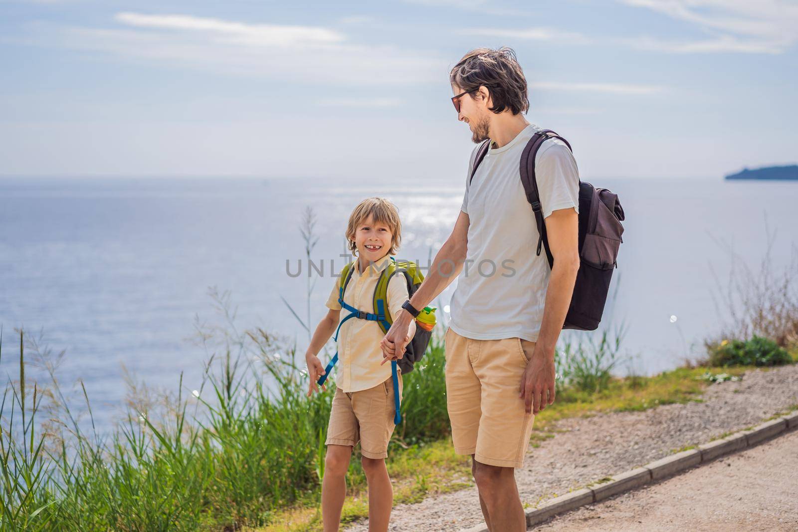 Dad and son tourists walks along the coast of Budva in Montenegro by galitskaya