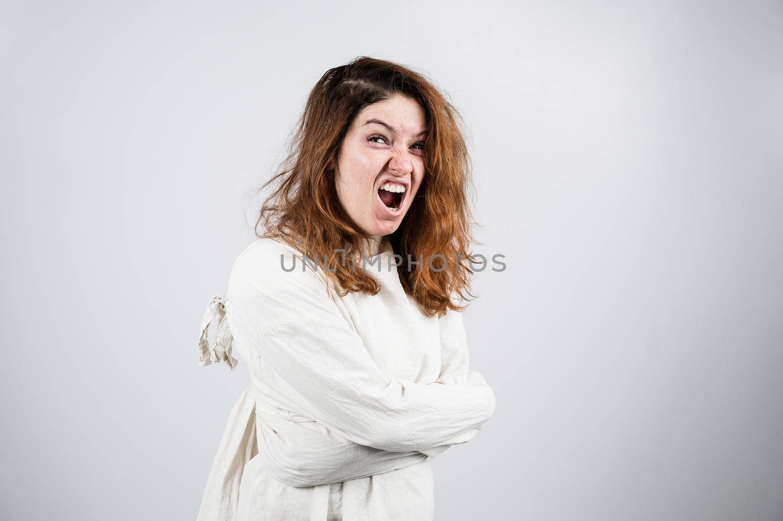 Close-up portrait of insane woman in straitjacket on white background. by mrwed54