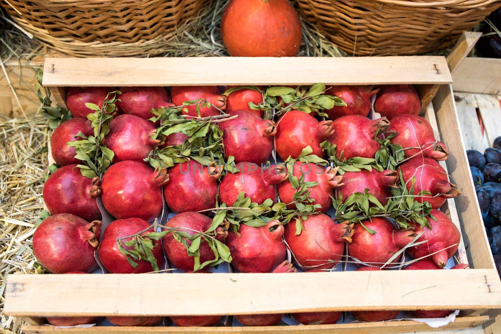 Fresh harvest, pomegranates in a box are sold in the market