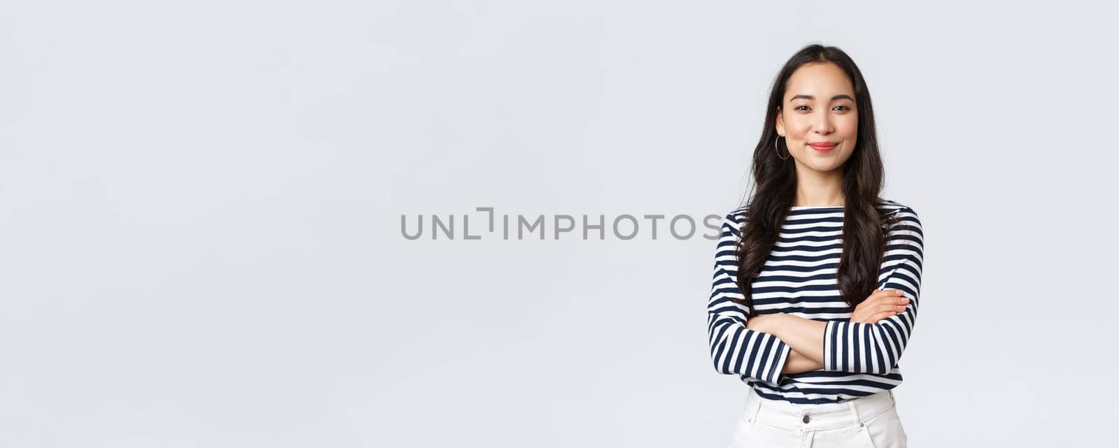 Lifestyle, beauty and fashion, people emotions concept. Confident good-looking young successful woman over white background, smiling and cross arms chest self-assured pose, white background.