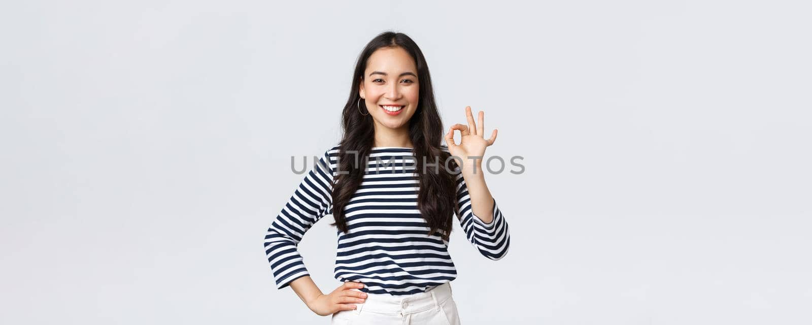 Lifestyle, beauty and fashion, people emotions concept. Satisfied good-looking female guarantee quality of product, recommend advertisement, showing okay sign, say no problem, all good.
