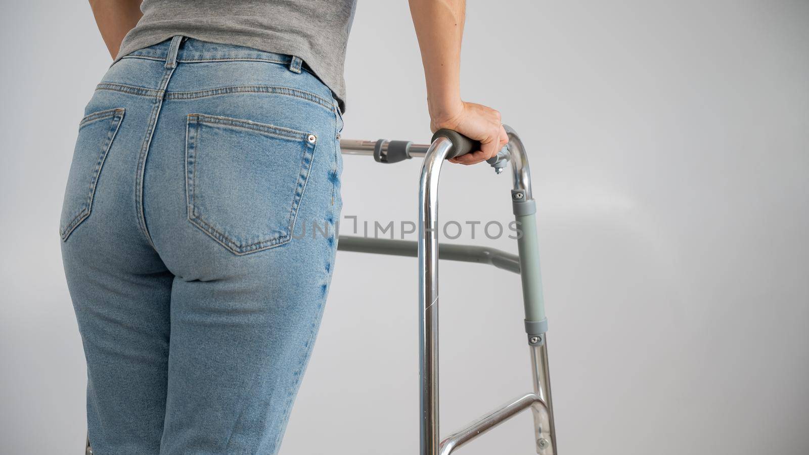 A woman is walking with a walker on a white background.