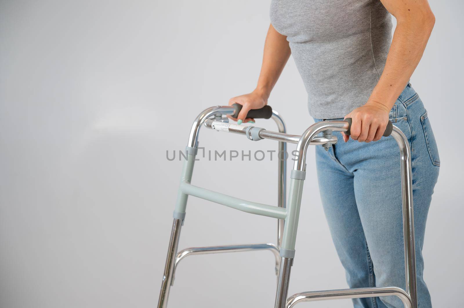 A woman is walking with a walker on a white background.