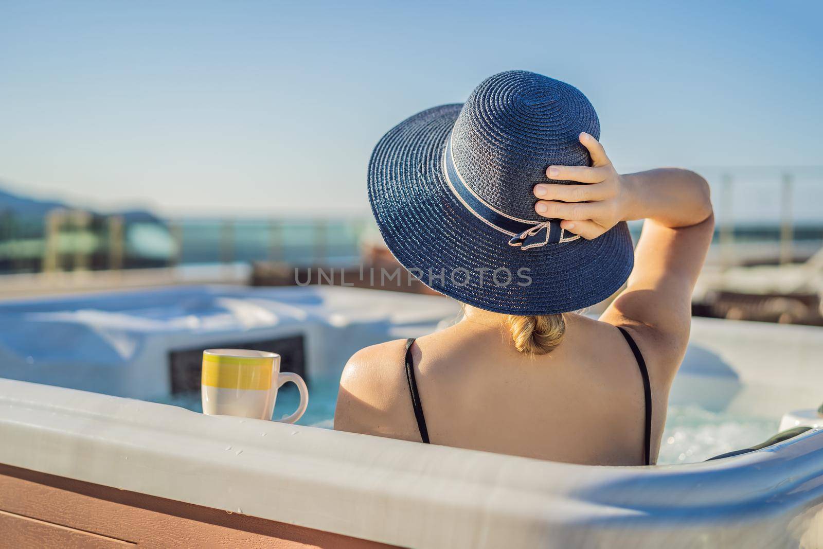 Portrait of young carefree happy smiling woman relaxing at hot tub during enjoying happy traveling moment vacation life against the background of green big mountains.