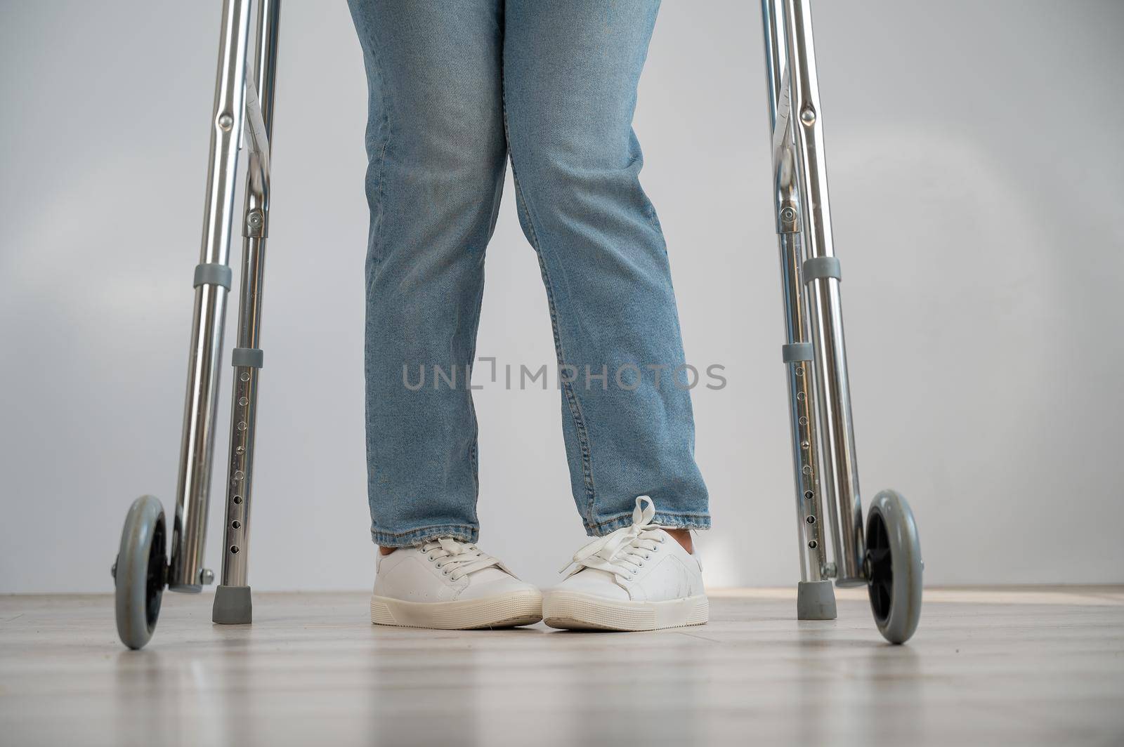 Close-up of female legs with walkers. The girl walks with the help of special equipment