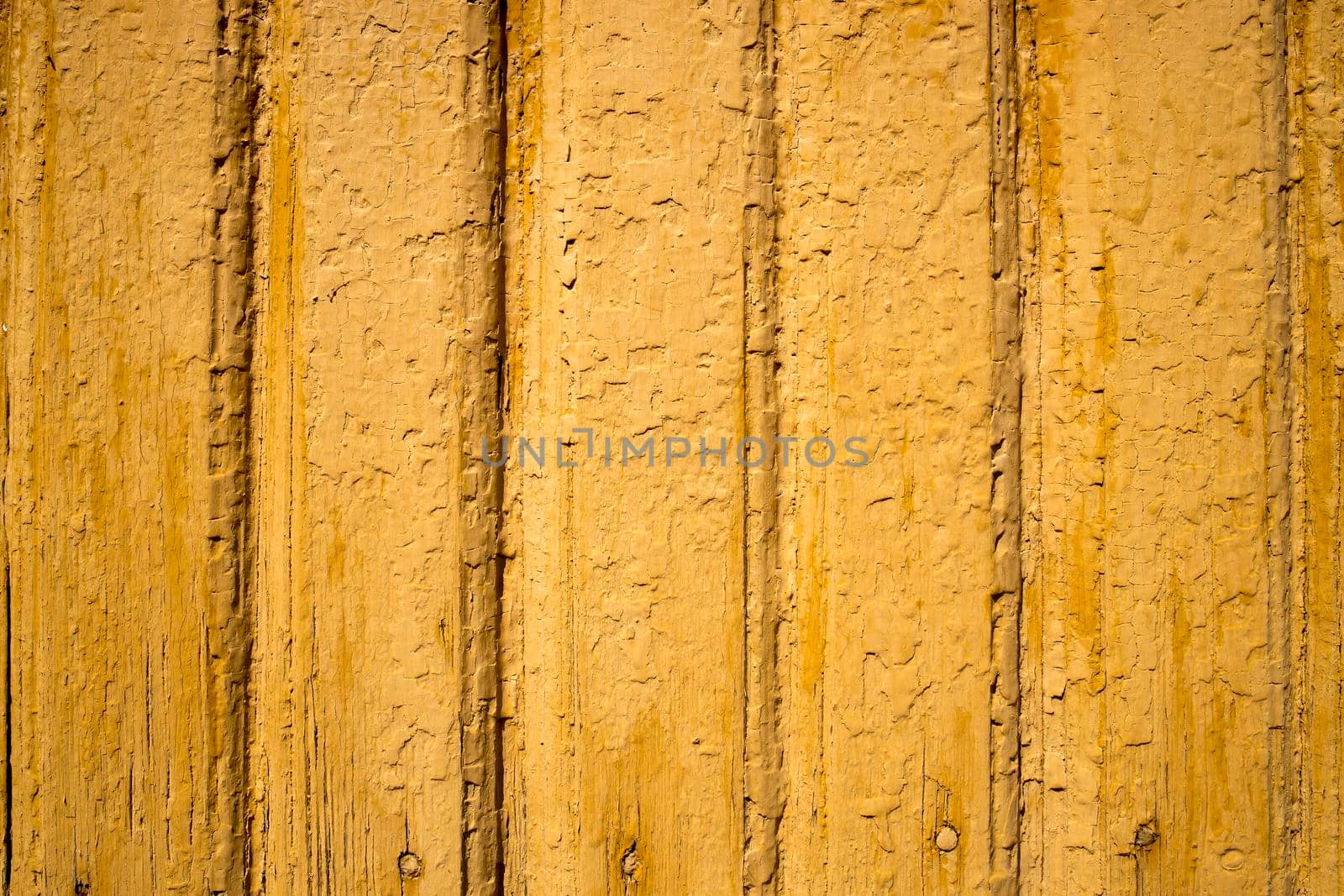 Texture of a yellow painted wall of wood planks with peeling paint by elenarostunova