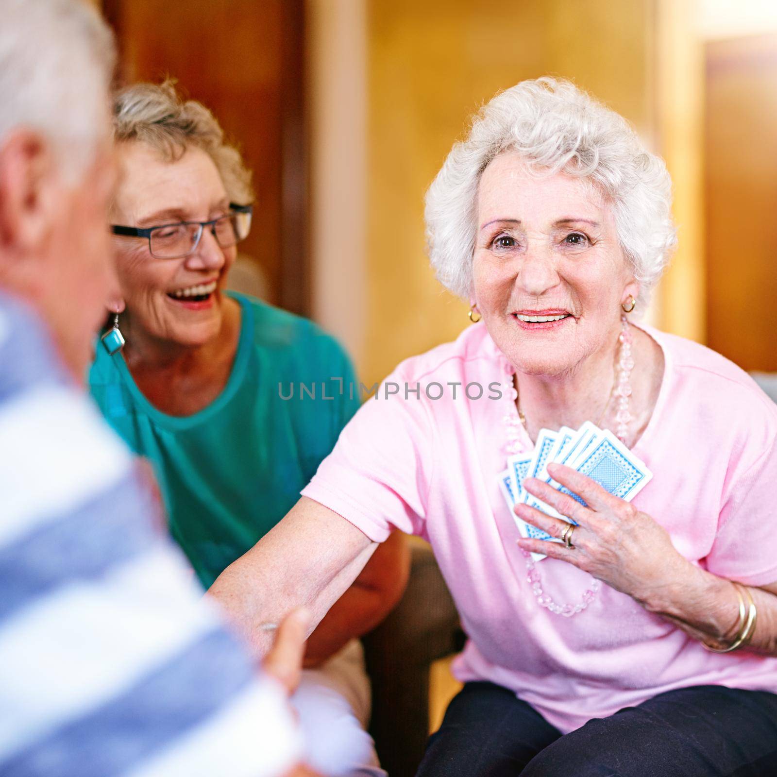 You cant see my cards. Cropped shot of seniors playing cards in their retirement home. by YuriArcurs