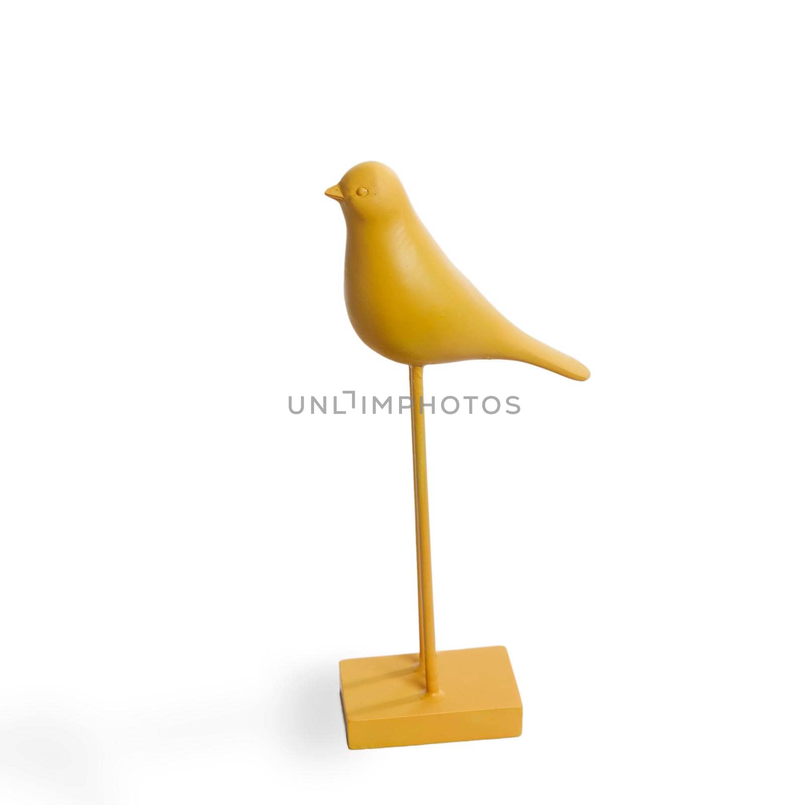 Wooden figurine of a yellow bird with long legs. Minimalism. Scandinavian style.