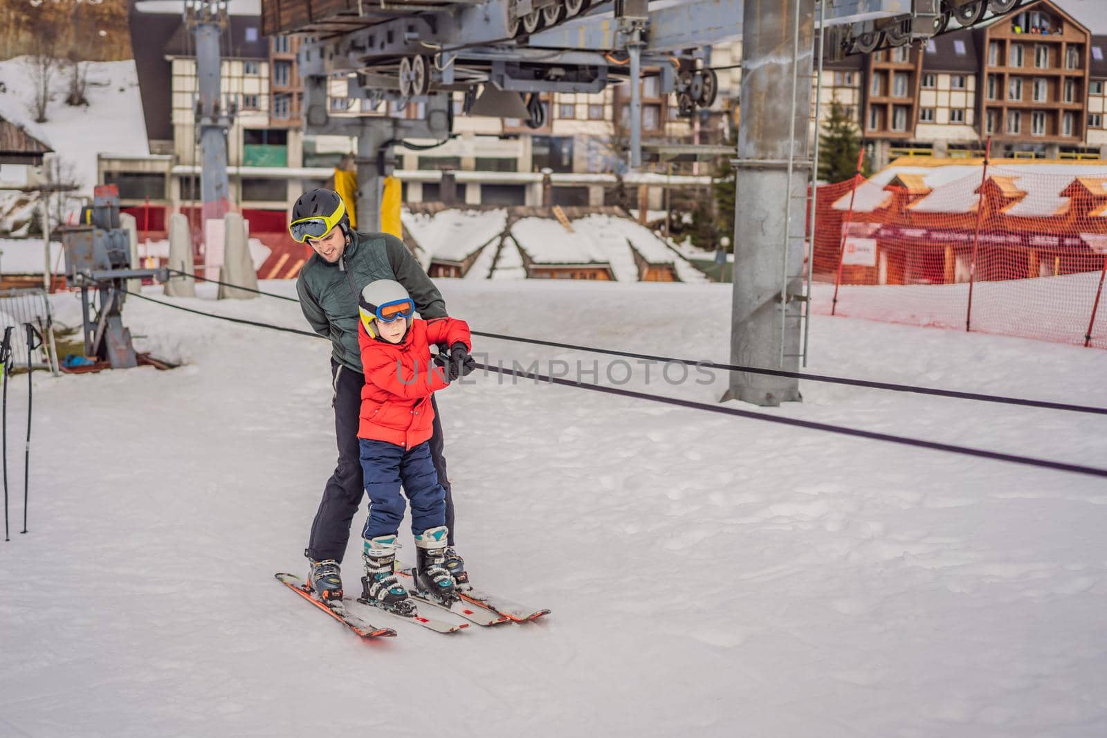 Instructor teaches boy skier to use on ski lift.