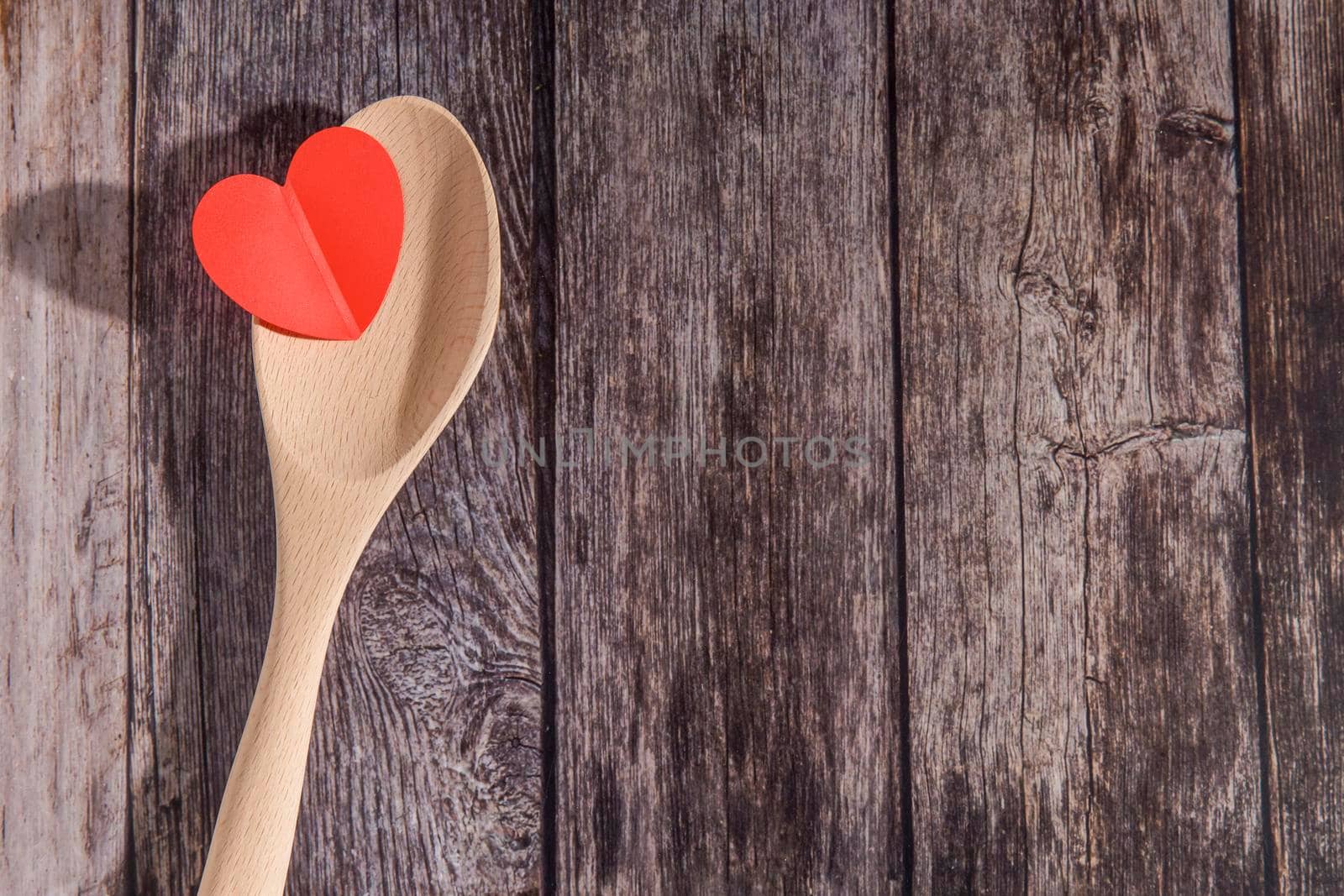 Wooden spoon filled with felt hearts on a wooden table. Concept. Place for text. Copy space by elenarostunova