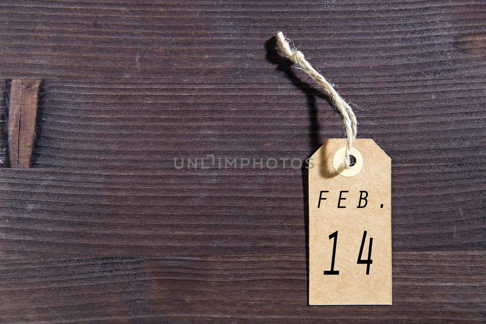 Blank white tag with string on wooden brown background. Copy space