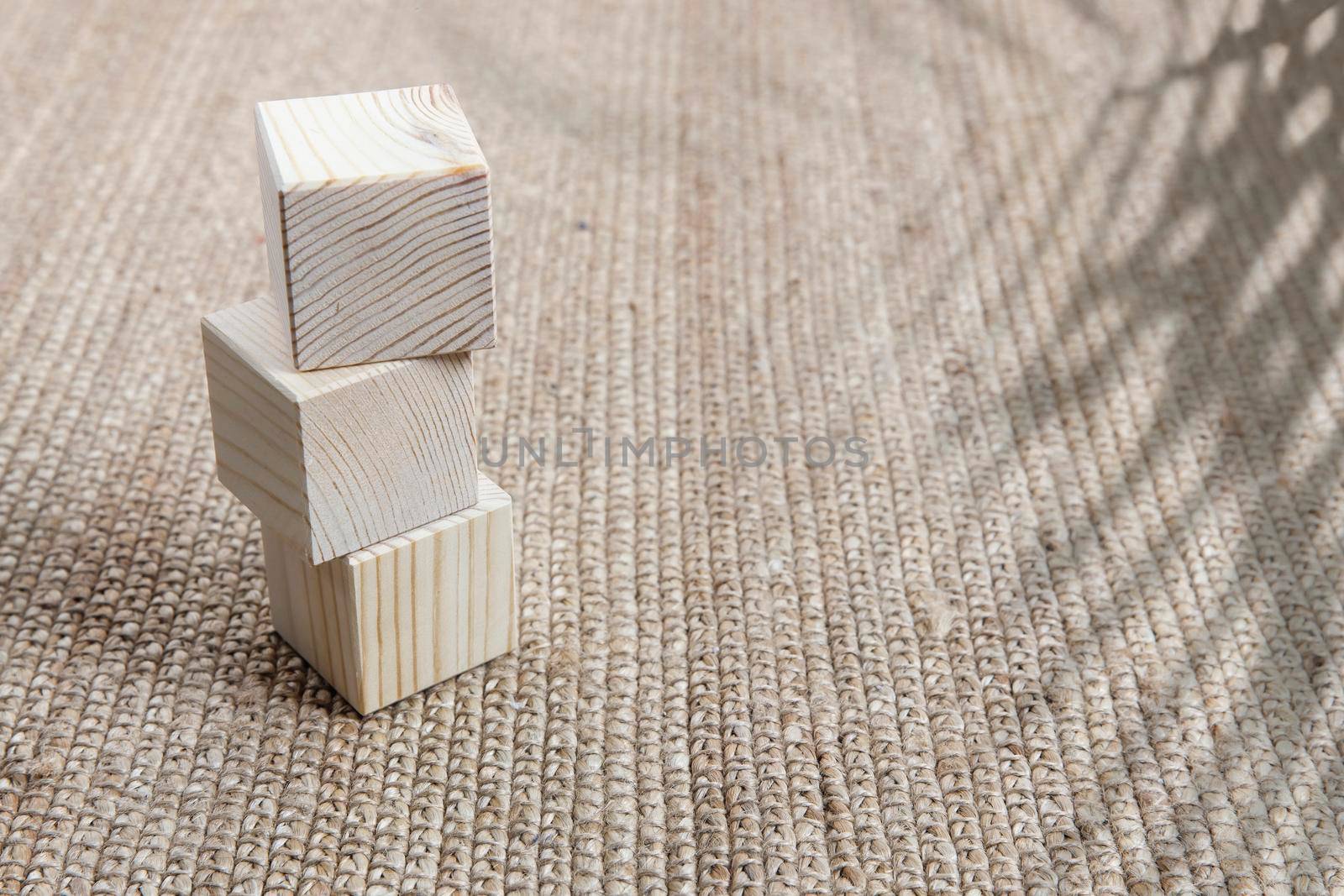 Wooden cubes on a wicker mat, shadow from a palm tree. Empty space for text.