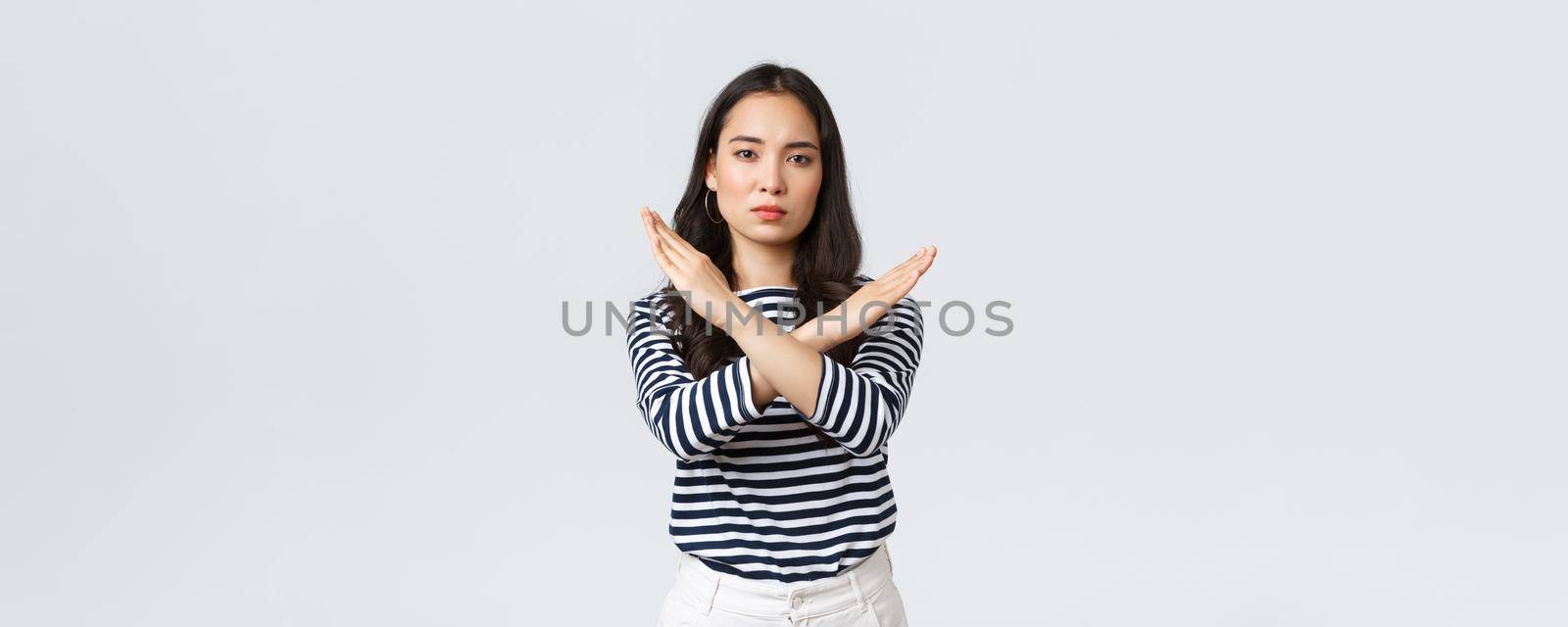 Lifestyle, beauty and fashion, people emotions concept. Serious-looking displeased asian woman tell to stop, showing cross sign in prohibition, disapprove action, give warning or restrain someone.