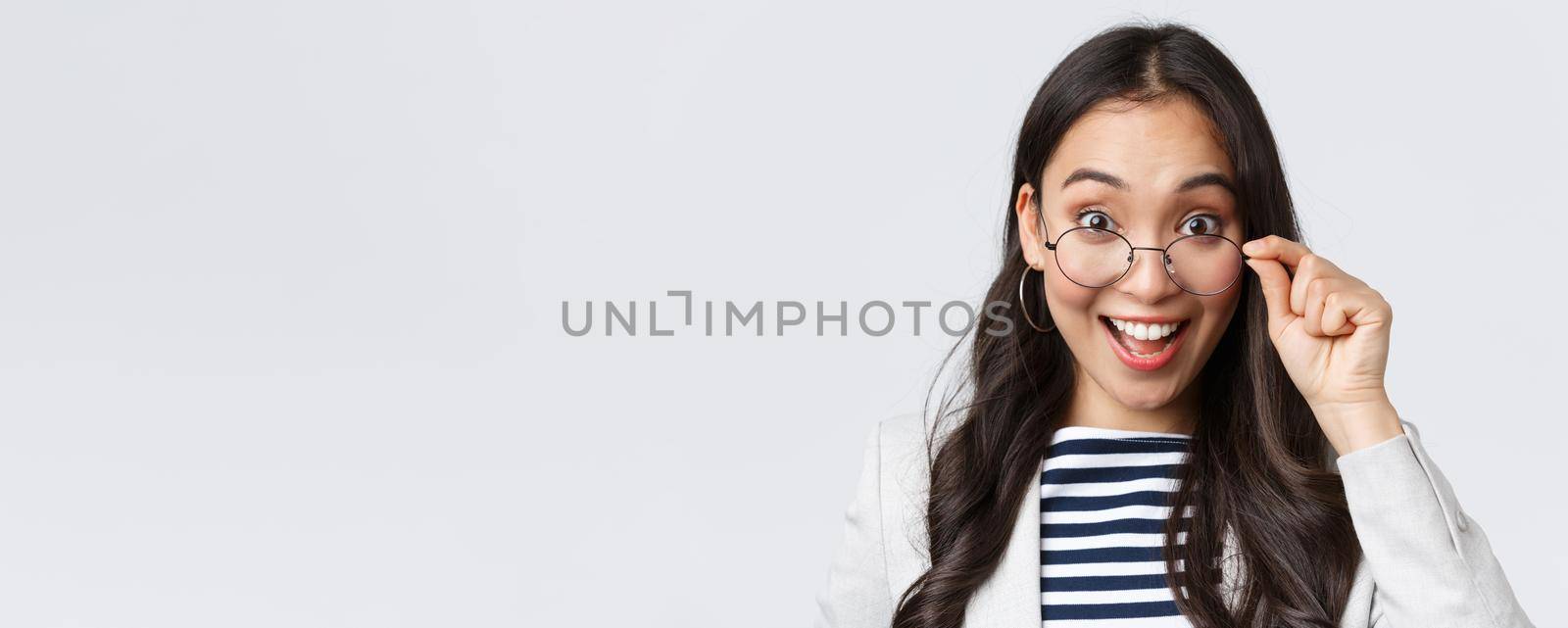 Business, finance and employment, female successful entrepreneurs concept. Excited happy asian office worker take-off glasses and smiling astonished as receive awesome deal.