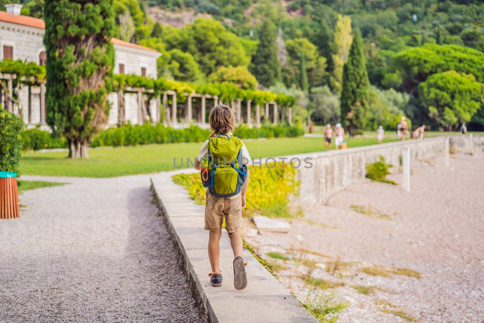 Boy tourist walking together in Montenegro. Panoramic summer landscape of the beautiful green Royal park Milocer on the shore of the the Adriatic Sea, Montenegro.