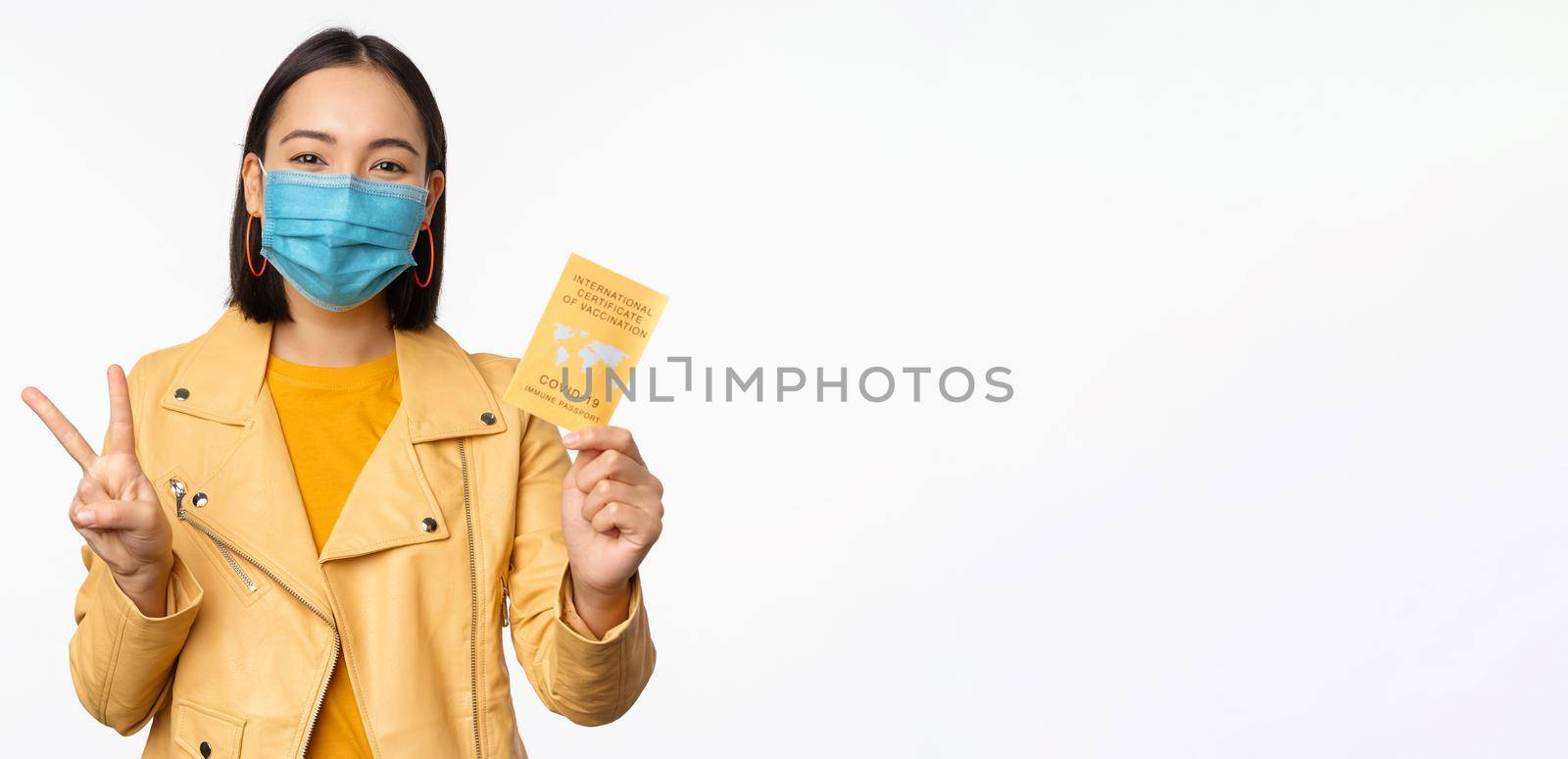 Hey you got point. Cheerful cute asian lively girl dark short haircut pointing camera finger-pistol smiling broadly, encourage friend make move, congratulate coworker good job, stand blue background.