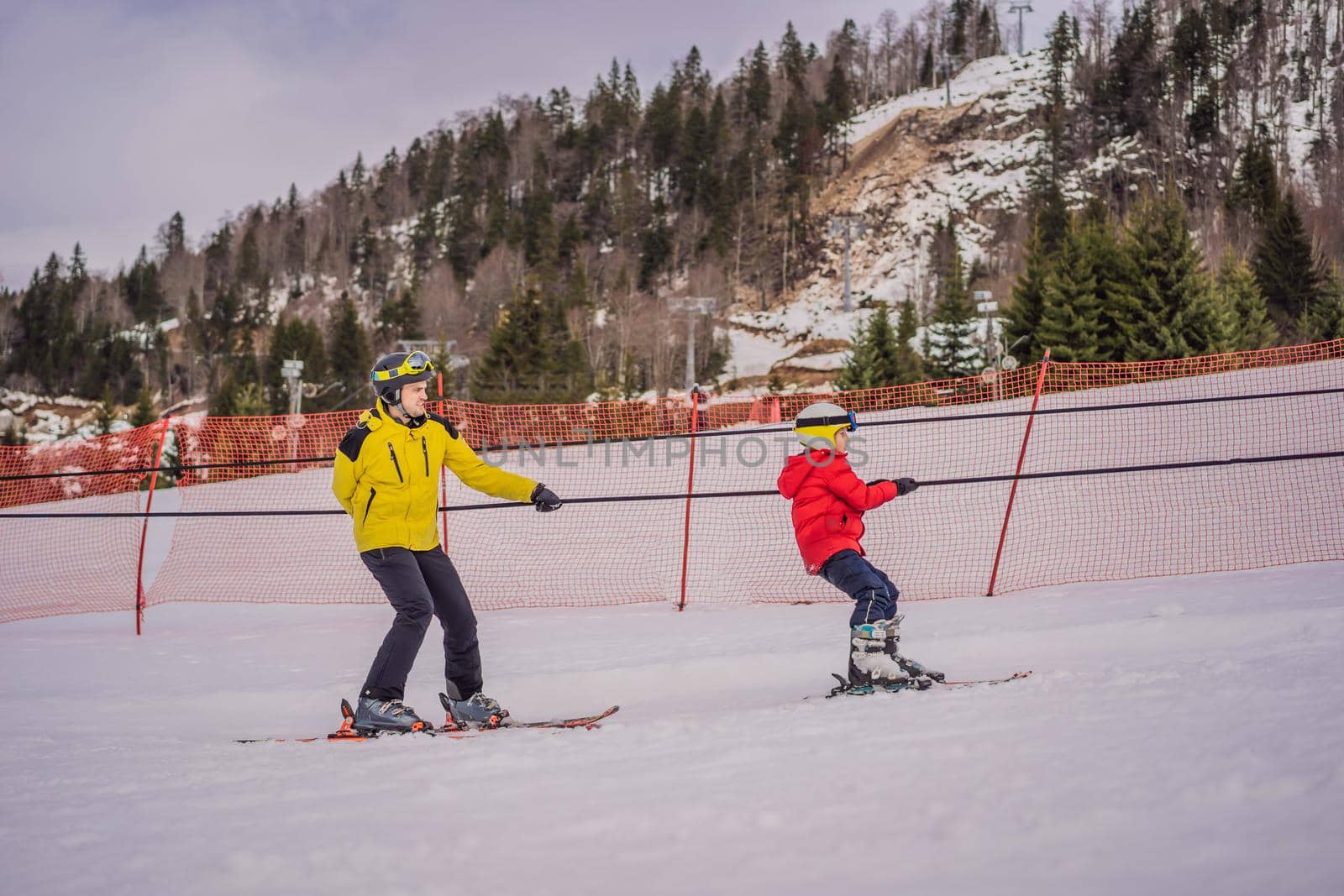 Instructor teaches boy skier to use on ski lift by galitskaya