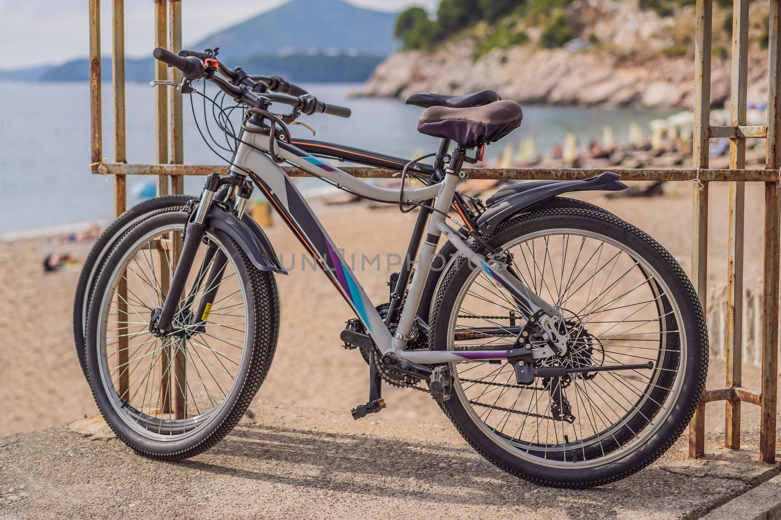 Bicycle stands at a metal railing against the background of the sea. A lady's bicycle is leaning against the shiny handrails. Cycling along the sea embankment by galitskaya