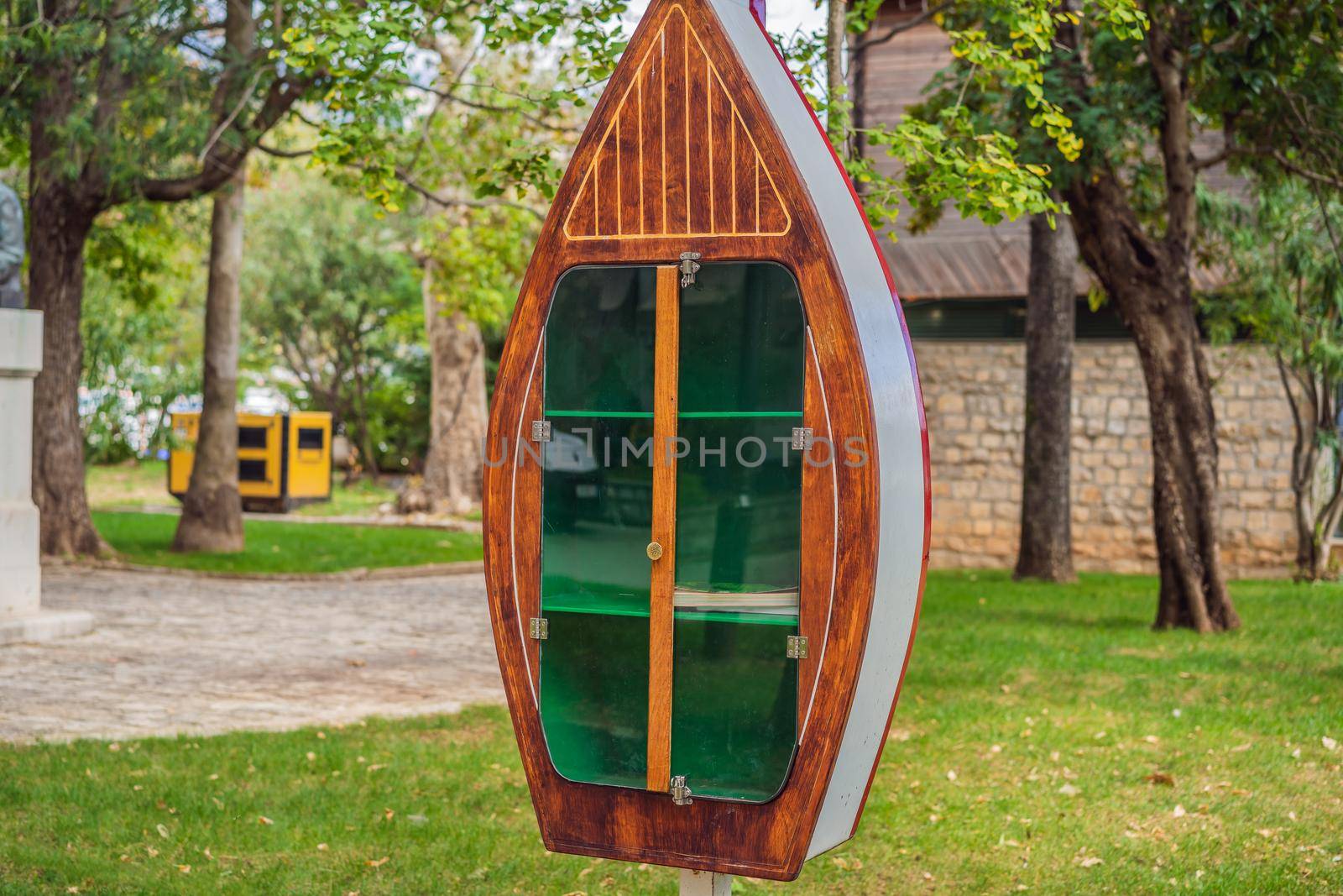 Outdoor library bookcase with books in Wollongong Botanic Garden on sunny day by galitskaya