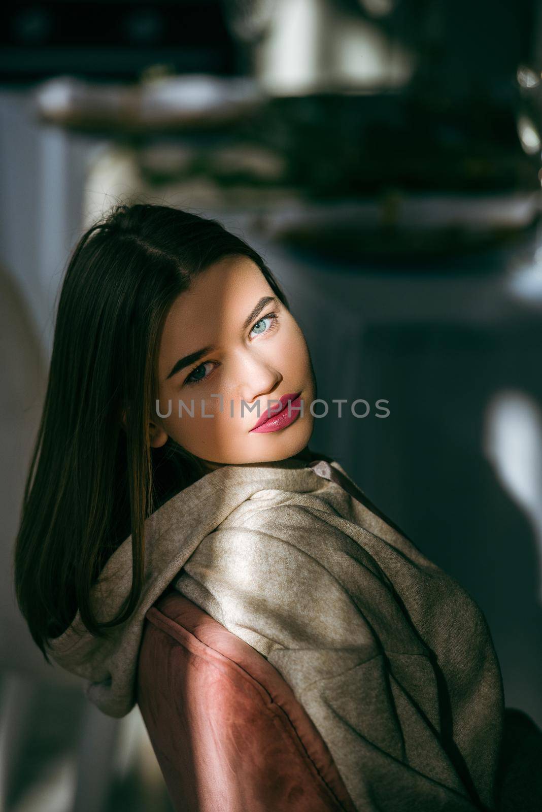 portrait of beautiful gentle woman in a beige sports jacket in the sunshine. Black long hair. sensuality and tenderness. Big red lips